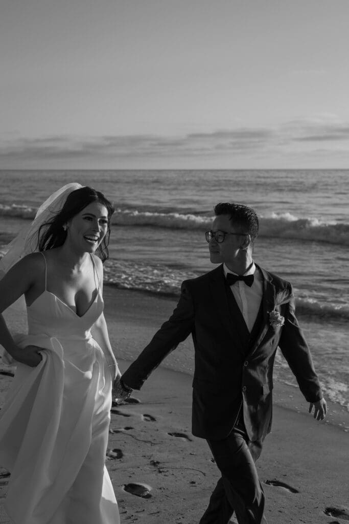Bride and groom walking together in black and white.