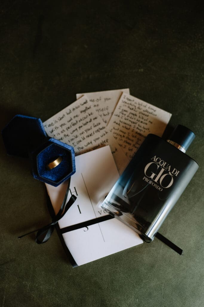 Groom details: ring, cologne, love letters, and vow book.