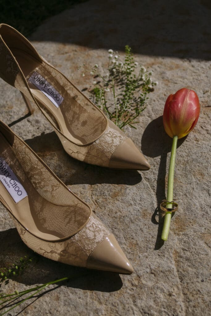 Details of wedding shoes and wedding ring with florals.